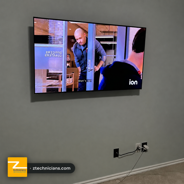 Wall-mounted TV installation on a gray wall by Z Technicians